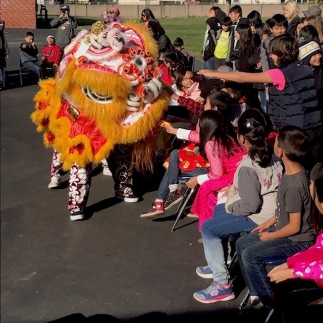 Scholars interact with the Lion as it approaches them.